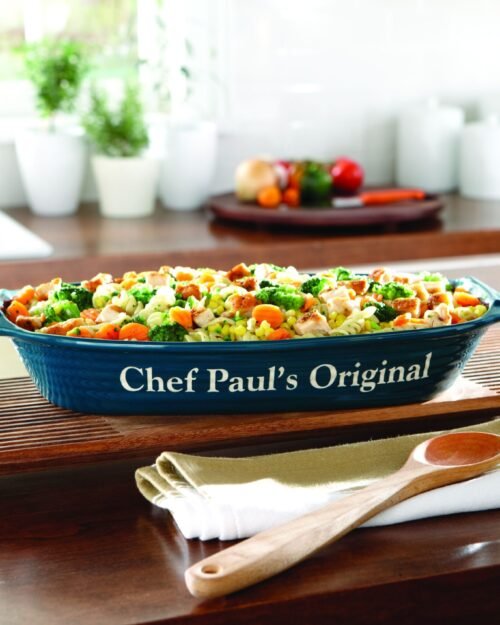 Ceramic baking dish with wooden spoon on a kitchen counter