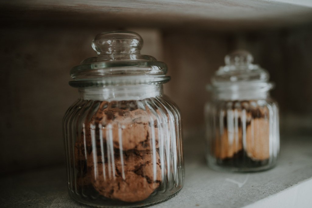 Food storage jars arranged on wooden kitchen shelves